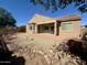 A backyard has a covered patio and a landscaped area with rocks and greenery at 16205 W Berkeley Rd, Goodyear, AZ 85395