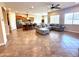 Spacious living room featuring tile floors that connect to the open kitchen and dining area at 16205 W Berkeley Rd, Goodyear, AZ 85395