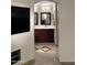 Elegant bathroom vanity with dark wood cabinetry and neutral tile flooring with decorative inlay at 45737 W Ranch Rd, Maricopa, AZ 85139