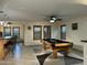 Spacious game room features a pool table, stylish ceiling fan, and bright natural light at 45737 W Ranch Rd, Maricopa, AZ 85139