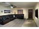Comfortable living room features a leather sectional sofa, neutral carpet, and plenty of natural light at 45737 W Ranch Rd, Maricopa, AZ 85139