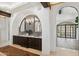 Beautiful bathroom featuring dual sinks, decorative tile, arched doorway and rich wood cabinetry at 21868 E Stacey Rd, Queen Creek, AZ 85142