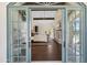Spacious bedroom boasts wood floors, a fireplace, and large windows for natural light, seen through doors at 21868 E Stacey Rd, Queen Creek, AZ 85142