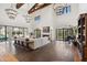 Expansive living room boasts beamed ceilings, chandeliers, fireplace, and grand piano at 21868 E Stacey Rd, Queen Creek, AZ 85142