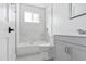 Bright bathroom featuring a shower-tub combo, marble-patterned tile, and a sleek white vanity at 4333 N 59 Th Ave, Phoenix, AZ 85033