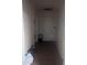 Hallway view with tiled flooring, a white door, and neutral walls at 3802 N 79Th Ave, Phoenix, AZ 85033