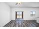 Bright living room with wood-look flooring, ceiling fan, and sliding glass doors to the backyard at 24594 W St Catherine Ave, Buckeye, AZ 85326