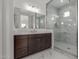 Bathroom featuring a marble shower, matching floors, wood cabinets, and a large mirror at 19539 E Estrella Rd, Queen Creek, AZ 85142