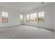 Sunlit bedroom with plush carpet and large windows offering neighborhood views at 19539 E Estrella Rd, Queen Creek, AZ 85142