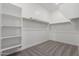 A large, walk-in closet featuring carpeted floors, shelves, and rods for clothing storage at 19539 E Estrella Rd, Queen Creek, AZ 85142