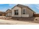 Exterior shot of a single-Gathering home with stone accents, desert landscaping, and large windows at 19539 E Estrella Rd, Queen Creek, AZ 85142