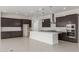 Spacious kitchen featuring dark wood cabinets, a white quartz island and stainless steel appliances at 19539 E Estrella Rd, Queen Creek, AZ 85142