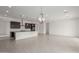 Spacious living room featuring a modern kitchen with dark cabinetry and pendant lighting at 19539 E Estrella Rd, Queen Creek, AZ 85142
