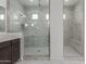 An elegant marble shower with glass doors and white tile at 19539 E Estrella Rd, Queen Creek, AZ 85142