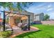 Backyard with a pergola covered seating area, fire pit, artificial turf, and desert landscaping at 2920 E Shady Spring Trl, Phoenix, AZ 85024