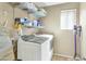 Functional laundry room with modern washer and dryer, shelving, and natural light at 2920 E Shady Spring Trl, Phoenix, AZ 85024