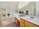 Bathroom featuring dual sinks, wood cabinets, and a separate tub at 7358 E Red Hawk St, Mesa, AZ 85207