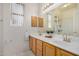 Bathroom showing dual sinks, wood cabinets, a large mirror, and tile flooring at 7358 E Red Hawk St, Mesa, AZ 85207