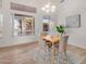 Sunlit dining room with a modern chandelier, large window, and view to the backyard at 7358 E Red Hawk St, Mesa, AZ 85207