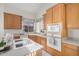 Bright kitchen features wooden cabinets, modern appliances and an island with cooktop and sink at 7358 E Red Hawk St, Mesa, AZ 85207