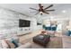 Bright living room featuring a wood accent wall and a contemporary ceiling fan at 4701 N 68Th St # 129, Scottsdale, AZ 85251