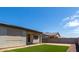 Landscaped backyard with artificial turf and covered patio at 19031 W Palo Verde Dr, Litchfield Park, AZ 85340