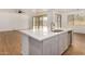 Open kitchen with gray cabinets, island, and sliding door access to backyard at 19031 W Palo Verde Dr, Litchfield Park, AZ 85340