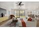 Bright living room featuring a white sofa, stylish decor, and sliding glass doors to the backyard at 19031 W Palo Verde Dr, Litchfield Park, AZ 85340