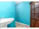 Small bathroom with pedestal sink and teal walls at 16021 N Verde St, Surprise, AZ 85378