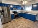 Bright kitchen with stainless steel appliances and blue cabinets at 16021 N Verde St, Surprise, AZ 85378