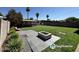 Expansive backyard with manicured lawn, tiled patio, and modern fire pit, perfect for outdoor gatherings at 2057 E Howe Ave, Tempe, AZ 85281