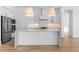 This stunning kitchen boasts modern pendant lighting, stainless steel appliances, and a spacious center island at 4353 N 203Rd Ave, Buckeye, AZ 85396