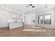 Spacious living room boasts wood-look floors, recessed lighting, and a view into the bright, modern kitchen at 4353 N 203Rd Ave, Buckeye, AZ 85396