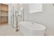 Bathroom showing soaking tub with stylish fixtures and walk-in shower with frameless glass at 4359 N 203Rd Ave, Buckeye, AZ 85396