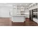 This kitchen features beautiful white cabinetry, stainless steel appliances, modern lighting and wood flooring at 4359 N 203Rd Ave, Buckeye, AZ 85396