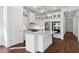 This kitchen features beautiful white cabinetry, stainless steel appliances, modern lighting and wood flooring at 4359 N 203Rd Ave, Buckeye, AZ 85396