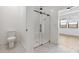 A modern bathroom features a sleek glass shower, modern toilet, and white tiled floor at 20311 W Montecito Ave, Buckeye, AZ 85396