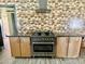 Stainless steel oven and gas range sit below stylish range hood and against patterned backsplash in this kitchen at 895 W Tyson St, Chandler, AZ 85225