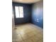 Bedroom featuring tile flooring, blue-painted walls, and a window at 5559 N 62Nd Ave, Glendale, AZ 85301