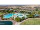 Gorgeous aerial view of community pool with lake and lush landscaping offering a refreshing oasis at 15175 S 185Th Ave, Goodyear, AZ 85338