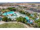 Breathtaking aerial view of community pool with lake and palm trees creating an idyllic retreat at 15175 S 185Th Ave, Goodyear, AZ 85338