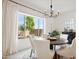 Elegant dining room with modern lighting, ample seating, and a view of the landscaped yard at 15175 S 185Th Ave, Goodyear, AZ 85338