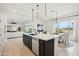Open-concept kitchen and living area with island, stainless steel appliances, and large windows for natural light at 15175 S 185Th Ave, Goodyear, AZ 85338
