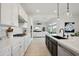 Modern kitchen showcasing sleek white cabinets, stainless steel appliances, and an open layout to the living area at 15175 S 185Th Ave, Goodyear, AZ 85338