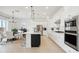 Bright, open kitchen boasts a large island with seating, adjacent to dining area with modern fixtures at 15175 S 185Th Ave, Goodyear, AZ 85338