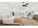 Bright main bedroom with a ceiling fan, plush rug, and large windows with shutters at 15175 S 185Th Ave, Goodyear, AZ 85338