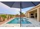 Stunning pool with desert landscaping and an outdoor umbrella offering a serene backyard retreat at 15175 S 185Th Ave, Goodyear, AZ 85338