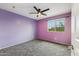 Spacious bedroom with purple walls and ceiling fan at 7351 W Palo Brea Ln, Peoria, AZ 85383