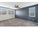 Bedroom with two windows, ceiling fan and grey carpet at 7351 W Palo Brea Ln, Peoria, AZ 85383