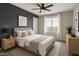 Stylish bedroom with a dark accent wall, natural light, and contemporary furnishings at 7351 W Palo Brea Ln, Peoria, AZ 85383